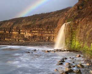 Preview wallpaper waterfall, stones, sea, cliffs, rainbow, nature