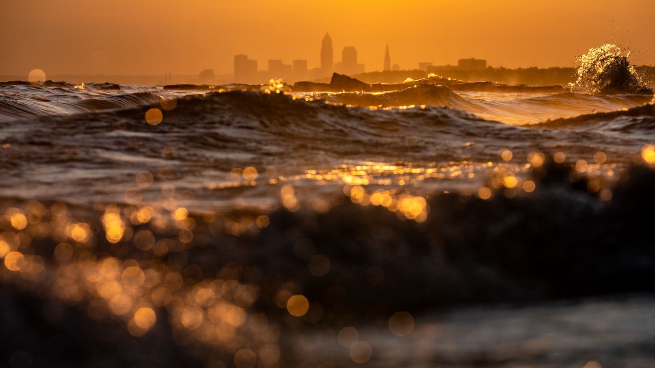 Wallpaper waves, sunset, city, buildings, silhouettes