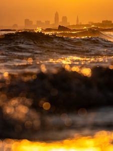Preview wallpaper waves, sunset, city, buildings, silhouettes