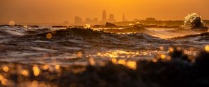 Preview wallpaper waves, sunset, city, buildings, silhouettes