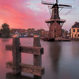 Preview wallpaper wind mill, buildings, river, sunset