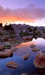 Preview wallpaper wind river range, wyoming, stones, river, mountains, evening, sky, grass