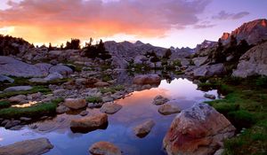 Preview wallpaper wind river range, wyoming, stones, river, mountains, evening, sky, grass