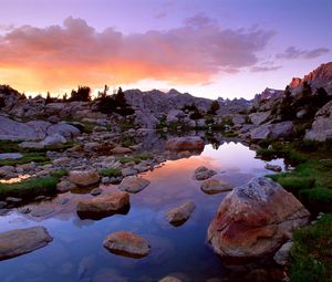Preview wallpaper wind river range, wyoming, stones, river, mountains, evening, sky, grass