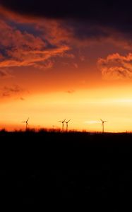 Preview wallpaper wind turbines, sunset, horizon, clouds