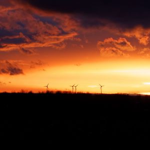 Preview wallpaper wind turbines, sunset, horizon, clouds