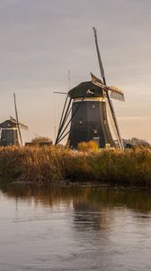 Preview wallpaper windmill, river, water, buildings, nature