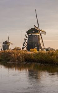 Preview wallpaper windmill, river, water, buildings, nature