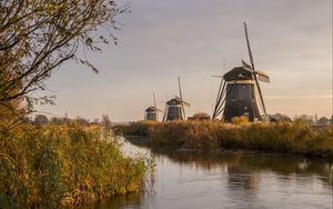 Preview wallpaper windmill, river, water, buildings, nature