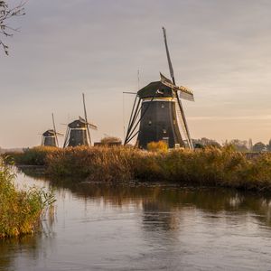 Preview wallpaper windmill, river, water, buildings, nature