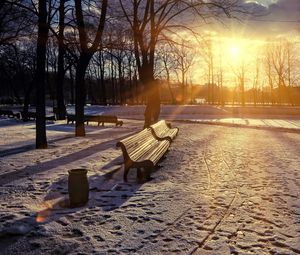 Preview wallpaper winter, park, sunset, bench, snow, sun